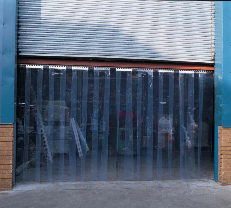A PVC curtain hung under a roller shutter door in a warehouse