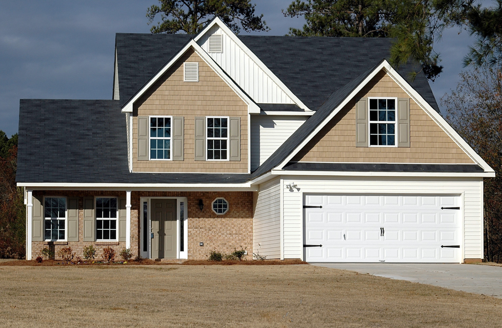 A large house with a brand new white garage door installed at the front.