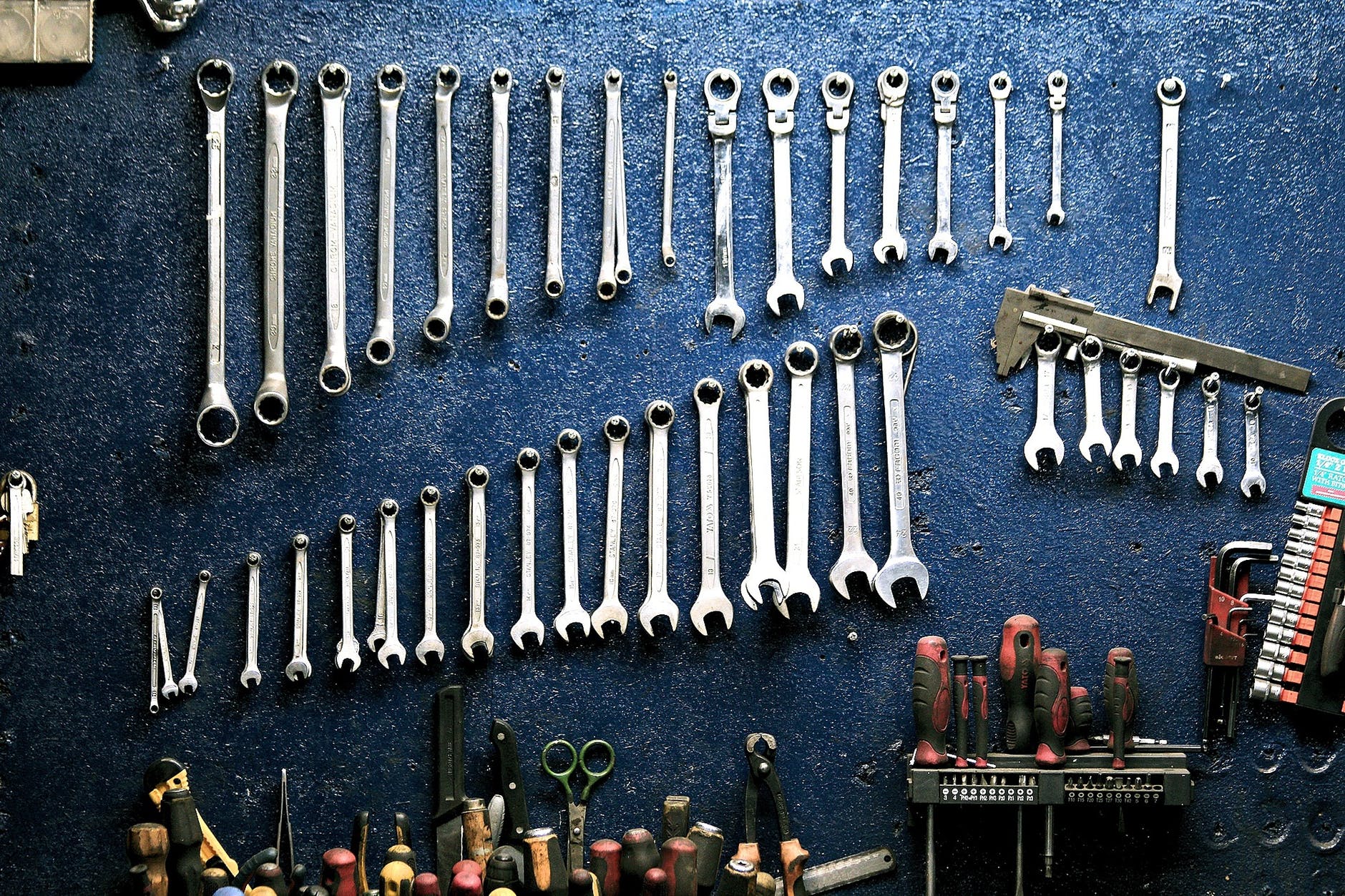 Tools lined up together on the inside of garage wall.